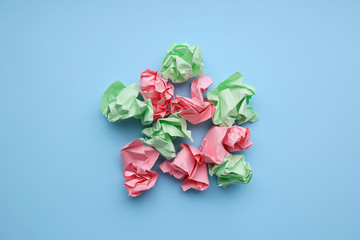 Multi-colored crumpled paper balls on a blue background.