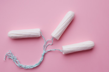 Medical female tampons on a pink background. White tampon for women. Menstruation, means of protection.