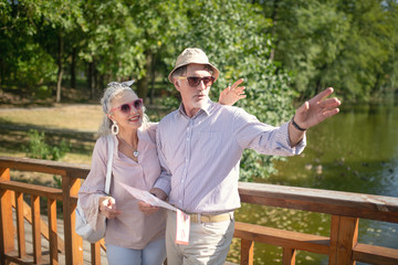 Beaming couple of tourists enjoying their walk in huge park
