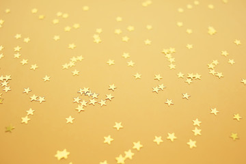 Golden stars on a yellow background, holiday concept