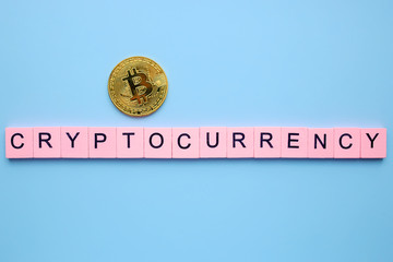 Cryptocurrency word wooden cubes on a blue background