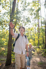 Bearded man wearing glasses walking in forest with wife