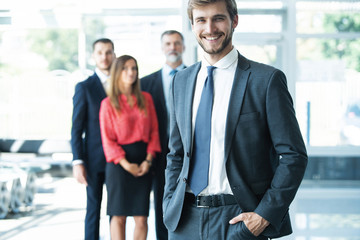 Fototapeta premium Team leader stands with coworkers in background