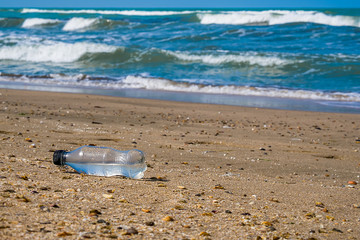Fototapeta na wymiar Plastic bottle washed up on the shore of the ocean.
