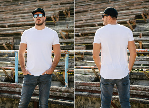 Hipster handsome male model with beard wearing white blank t-shirt and a baseball cap with space for your logo or design in casual urban style