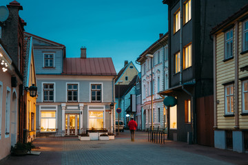 Fototapeta na wymiar Parnu, Estonia. Night View Of Puhavaimu Street With Old Buildings, Houses, Restaurants, Cafe, Hotels And Shops In Evening Night Illuminations
