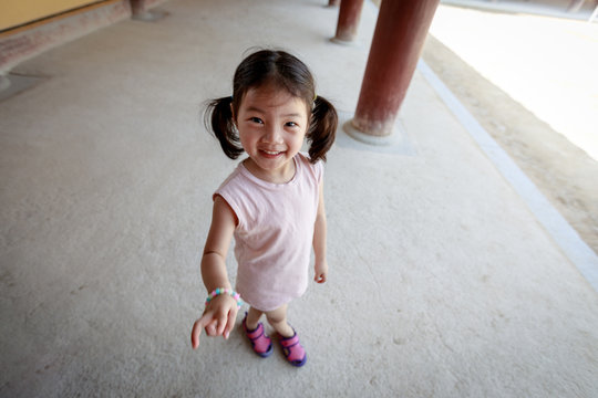 Cute little asian girl standing outside