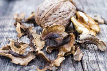 Walnut kernels and partitions near whole walnuts on a wooden table. The medicine for tinctures and decoctions.
