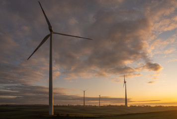 windmills on a field in Germany during a beautiful multicolored sunrise