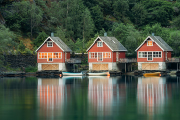 Fototapeta na wymiar Flam, Norway. Famous Red Wooden Docks In Summer Evening. Small Tourist Town Of Flam On Western Side Of Norway Deep In Fjords. Famous Norwegian Landmark And Popular Destination