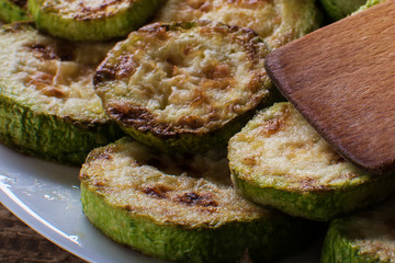 Fried zucchini with lemon zest and thyme. Selective focus.