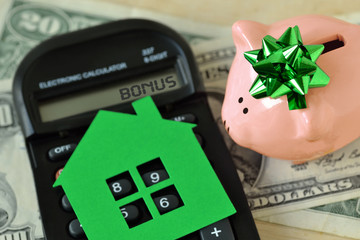 Piggy bank with calculator and paper house on dollar money background - Concept of saving money to...