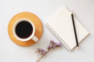 Creative flat lay of coffee with notebook on white desk with copy space.minimal.