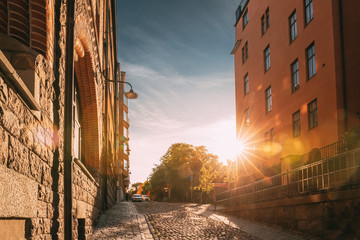 Stockholm, Sweden. Sunshine During Sunset Above Stockholm Street. Beautiful Street With Multi-storey House In Sunny Summer Evening. - obrazy, fototapety, plakaty