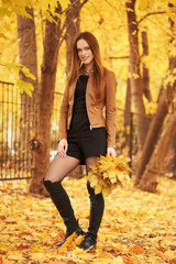 Full length portrait of a beautiful woman in the autumn park