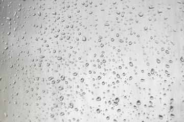 Water drops on window glass surface with blured nature background
