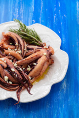 boiled octopus with garlic on white plate