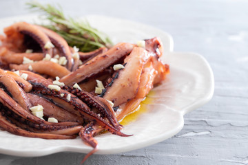 boiled octopus with garlic on white plate