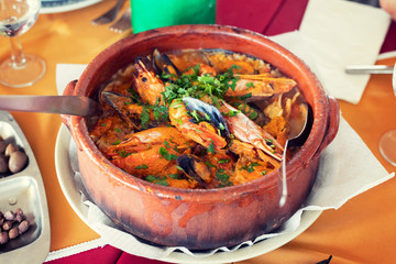 seafood rice in brown ceramic pot in restaurant