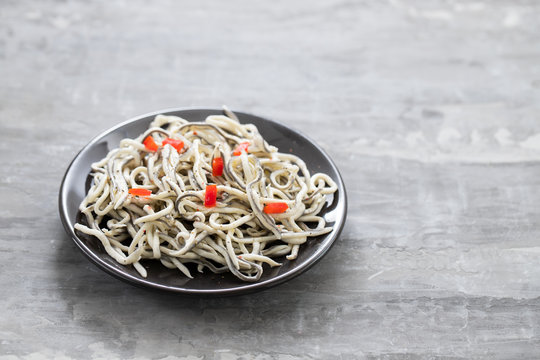 Traditional Spanish food. Gulas with oil on white plate.