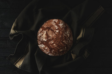 Freshly baked bread on black wooden background. Top view. Copy space.