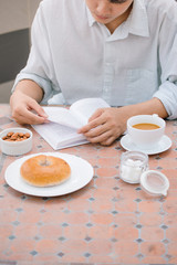 Portrait of a handsome man reading a book and enjoying his coffee.