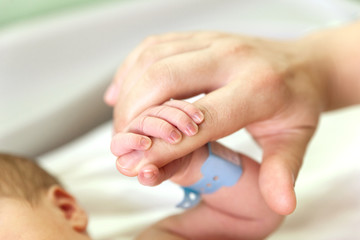 The baby clings to his father's finger