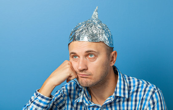Foil hat on man. Man with a bored face. Protects from reading think