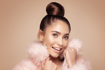 Fashionable smiling girl in pink eco fur.