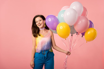 young happy party girl holding festive balloons isolated on pink