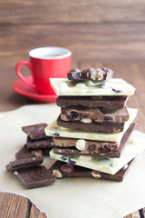 Pieces of white and dark chocolate with a cup of coffee. Handmade chocolate. Menu and greeting card design.
