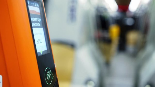Faceless passenger paying via electronic device in public transport. Detail view female choosing trip options on modern tram validator making payments via plastic card at blurred background