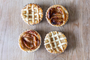 Homemade apple pies on a wooden table in a kitchen