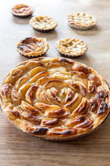Homemade apple pies on a wooden table in a kitchen