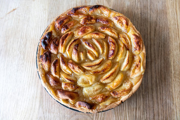 Homemade apple pies on a wooden table in a kitchen