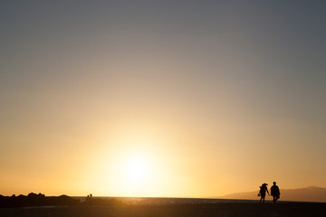 atardecer en Venice Beach con pareja paseando en la playa a contraluz