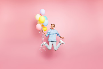 Full length body size photo of cheerfu positive cute nice screaming funny comic girl holding balloons with hands shouting flying jumping in blue sweatshirt sweater hoodie jeans denim isolated pastel