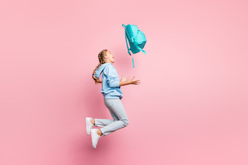Full body profile photo of pretty little lady jumping high go home after studying week throwing pupil backpack up air wear casual sweater clothes isolated pink color background