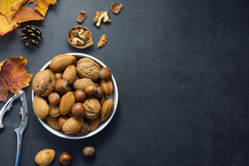 Mix of nuts - hazelnuts, almonds, walnuts in a basket over dark bckground. Healthy super food. Top view with copy space.