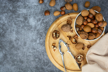 Mix of nuts - hazelnuts, almonds, walnuts in a basket over dark bckground. Healthy super food. Top view with copy space.