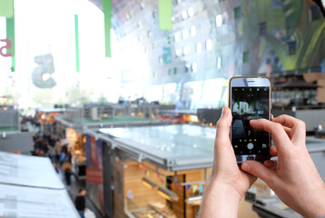 Person taking a photo of a big mall with his smartphone
