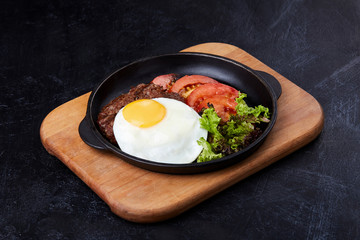 Pan winth fried egg, sliced tomatoes, salad and cutlet