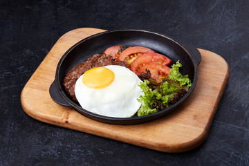 Pan winth fried egg, sliced tomatoes, salad and cutlet
