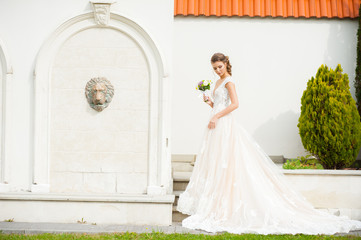 Fototapeta premium Beautiful happy bride in long wedding dress with wedding bouquet