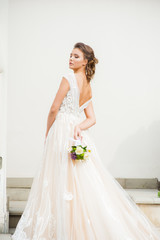 Fototapeta na wymiar Beautiful bride in long wedding dress with bouquet