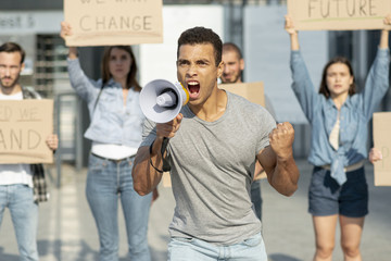 Man with megaphone protesting with activist behind