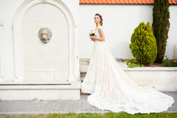 Fototapeta premium Beautiful happy bride in long wedding dress with wedding bouquet