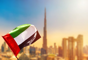 Amazing Dubai skyline cityscape with modern skyscrapers and UAE flag. Downtown of Dubai at sunny...