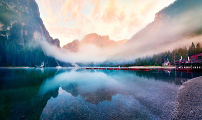 Foggy morning view of Braies (Pragser Wildsee) lake. Fantastic summer sunrise in...
