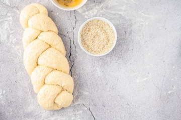 Raw loaf of challah Jewish bread on a light background. Copy space.